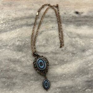 Rose colored gold plated chain link necklace with matching blue crystal pendant